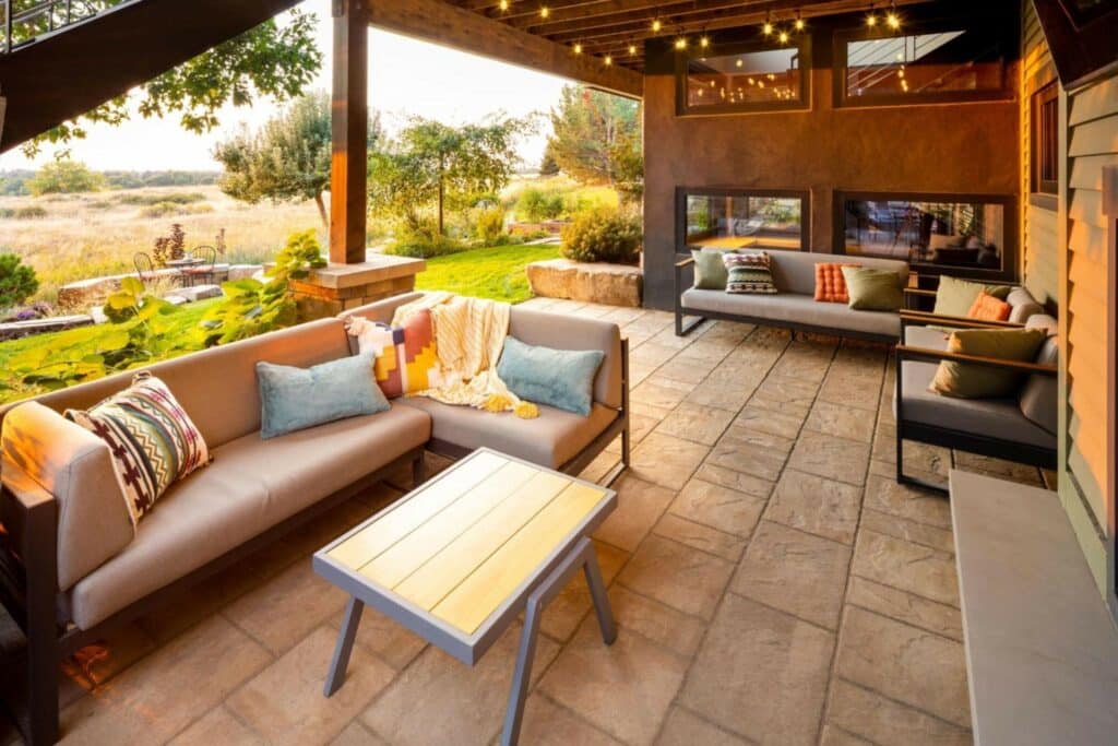 personalized outdoor living area with stone tiles, pergola, and modern, classy furniture